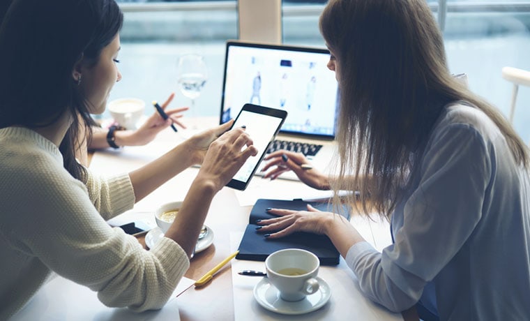 two women looking at ipad, testing